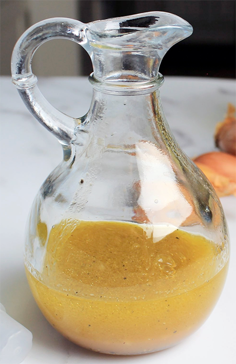 Basic olive oil, white wine vinegar and shallot vinaigrette in a jug