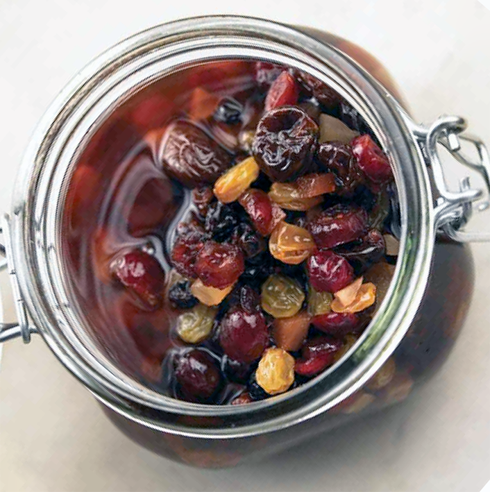 Dried fruit macerating in a jar of brandy