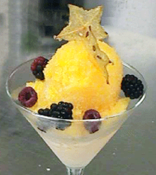 Mango granita served in a cocktail glass with fruit garnish