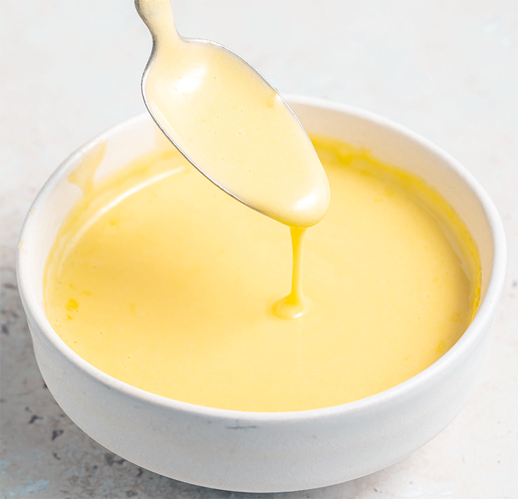 Hollandaise sauce in a white bowl