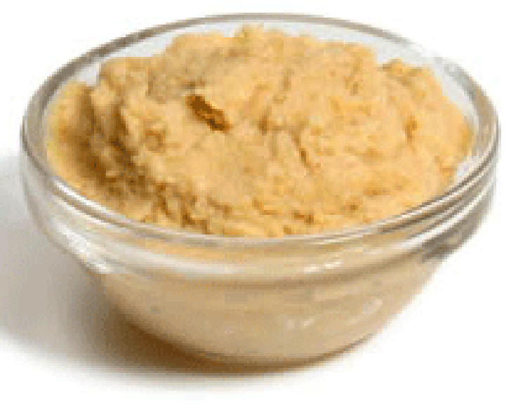 Hummus presented in a small glass bowl