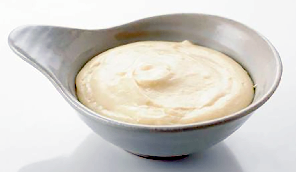 Mornay sauce in a white sauce boat