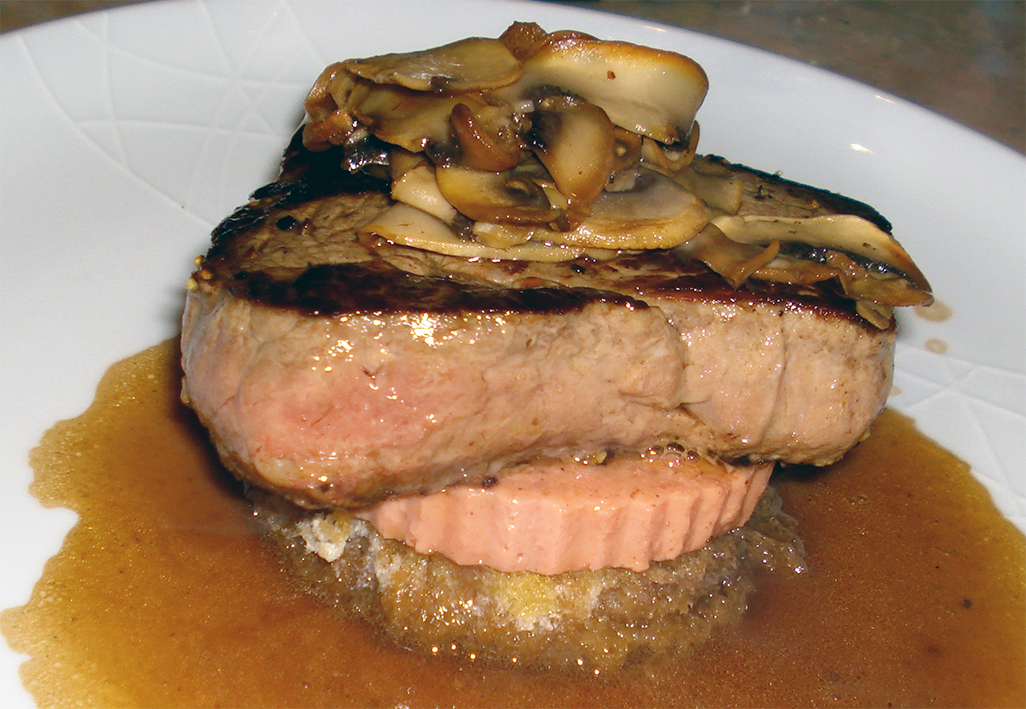 Tournedos rossini, beef steak served on a base of bread and pate and topped with mushrooms