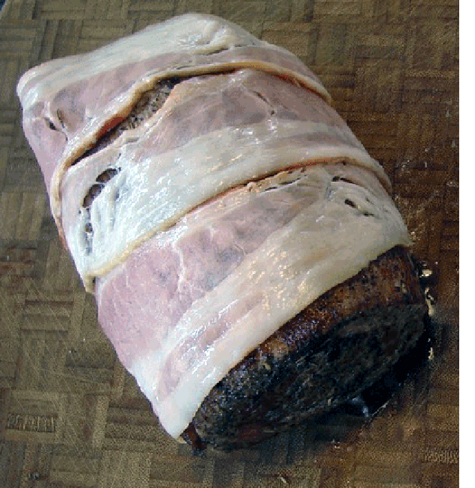 Seared venison steak barded with bacon