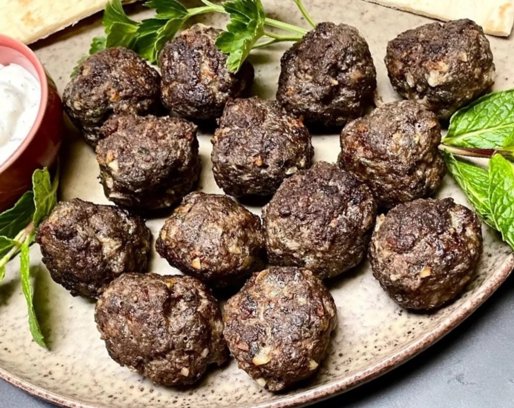 advieh spiced meatballs on a plate with yoghurt dressing