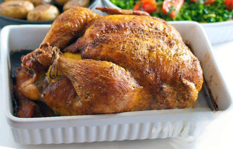 advieh spices roast chicken in a white roasting dish