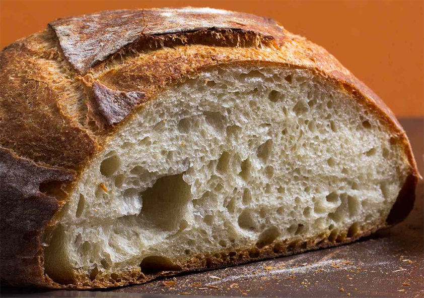alexanders seed bread with a slice removed from the front to reveal the inside of the loaf