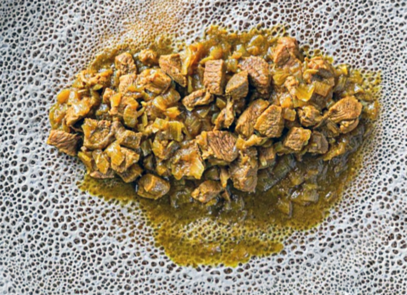 alicha sega wot, stewed beef with onions and spices on injera bread