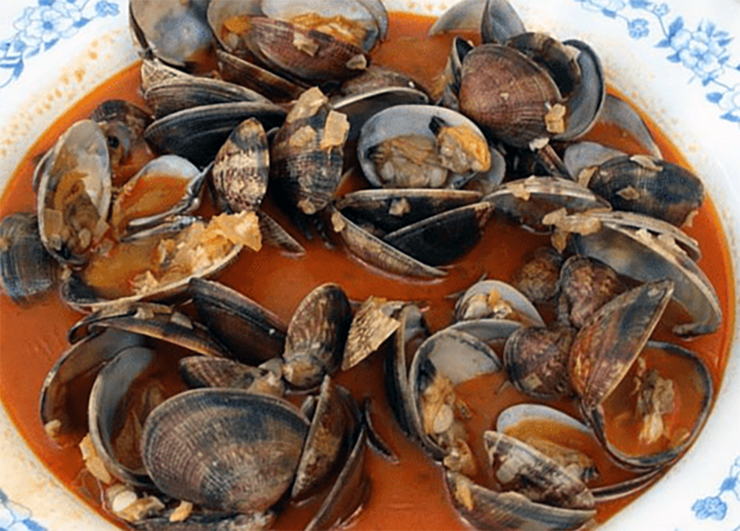 clams in a tomato sauce served in a bowl