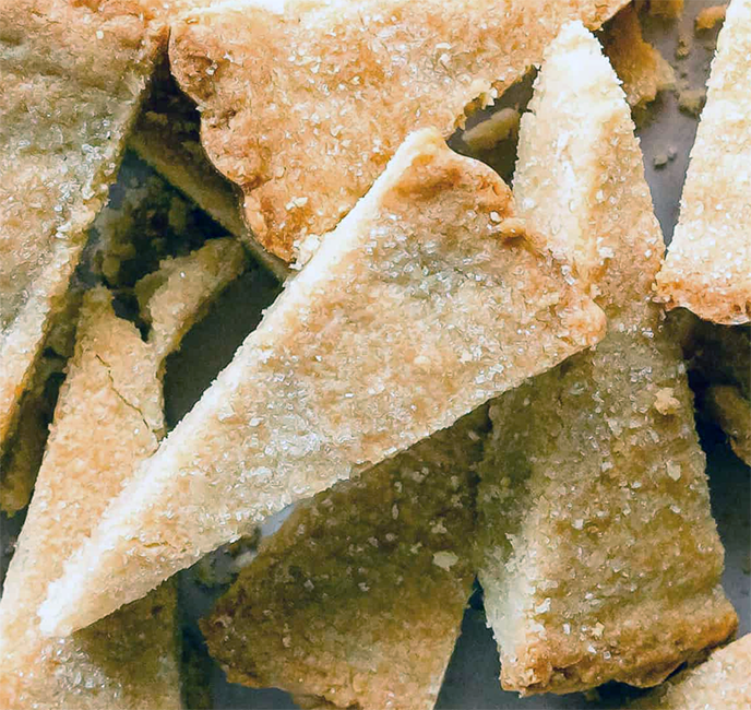slim wedges of almond shortbread piled on a plate