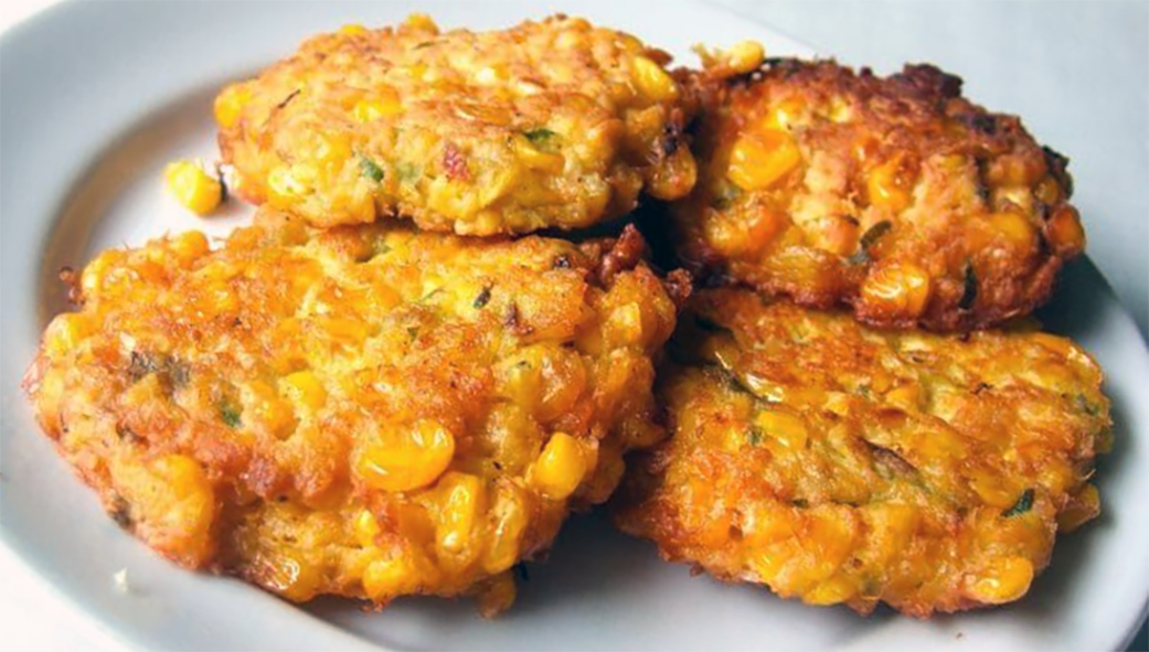 four Amish corn fritters arranged on a plate
