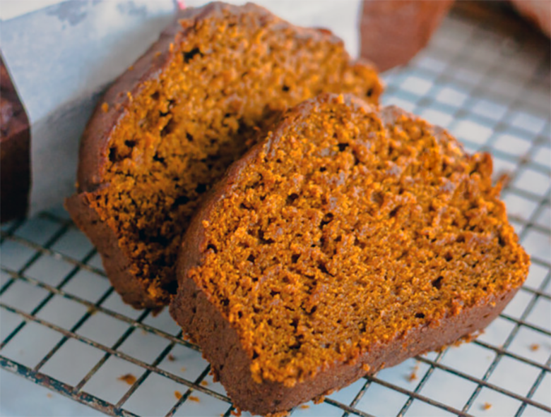 two slices of amish pumpkin bread on a wire cooling rack