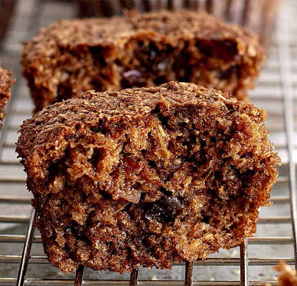 two split raisin bran muffins on a wire cooling rack