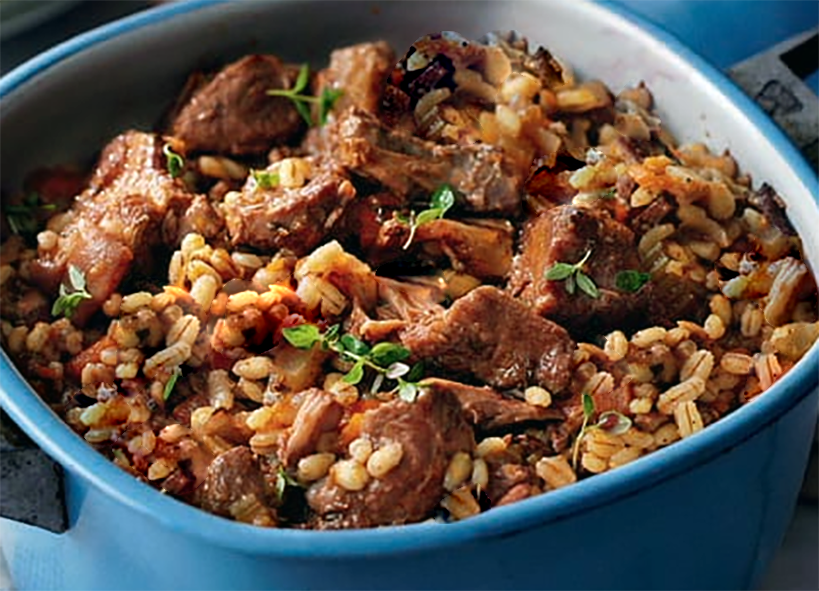 pork and grains stew with pearl barley in a casserole dish