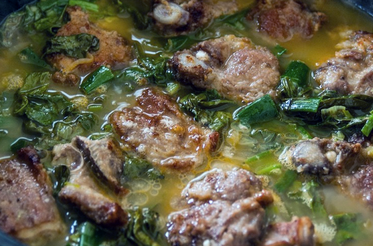 lamb cooking with spinach in a stew pot