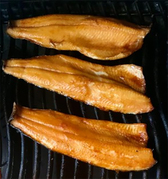 teriyaki-glazed trout fillets cooking on a barbecue