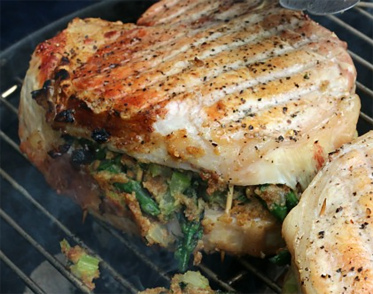 plum, nut and breadcrumb stuffed pork chop cooking on a barbecue