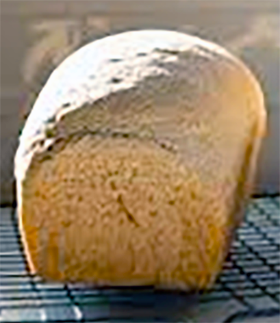 loaf of brown bread cooling on a wire rack