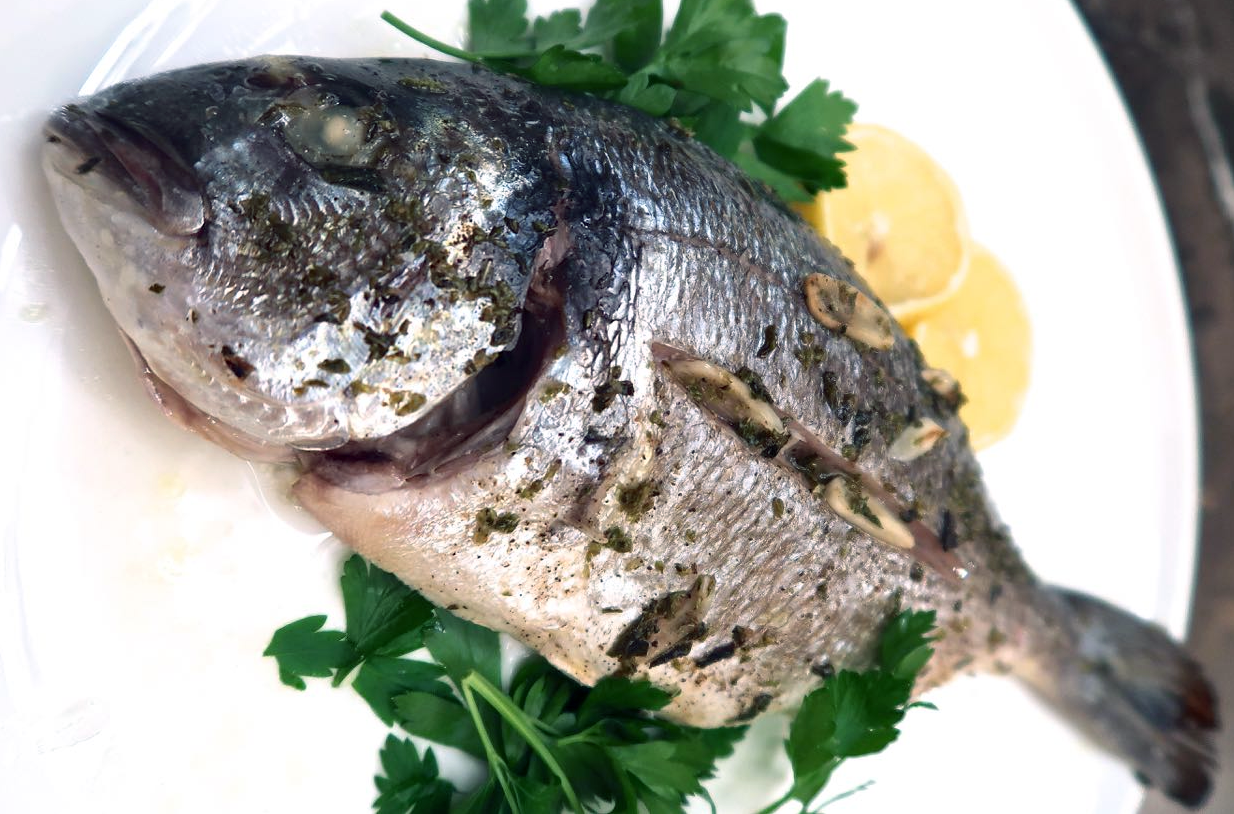 baked sea bream on a plate with parsley