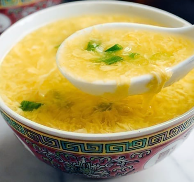 egg soup in an asian style bowl with a ceramic spoon