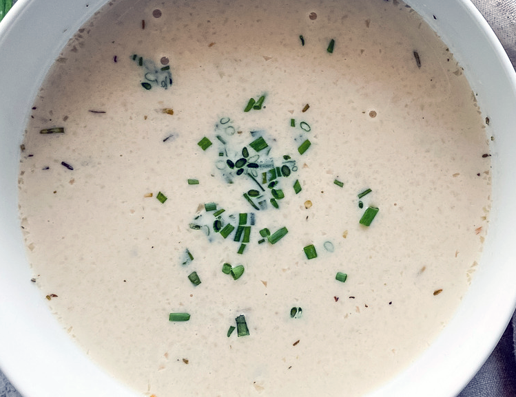 cream onion soup in a bowl garnished with snipped chives