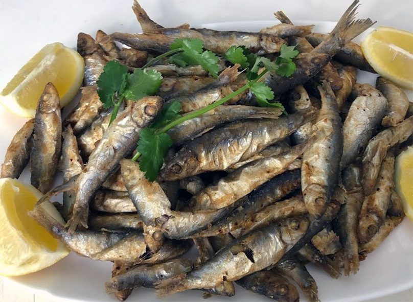 mound of deep fried whitebait with lemon wedges