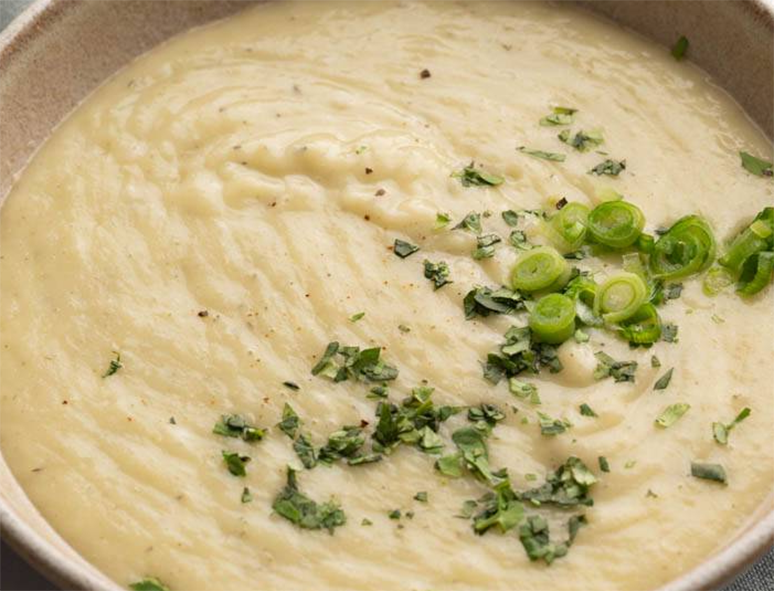 pureed turnip soup served topped with sliced spring onions