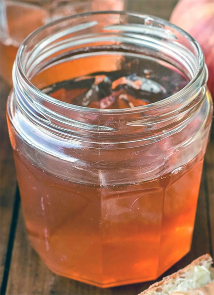 clear apple and bergamot leaf jelly in an unlidded jam jar