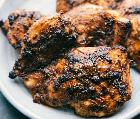 blackened chicken leg pieces on a plate