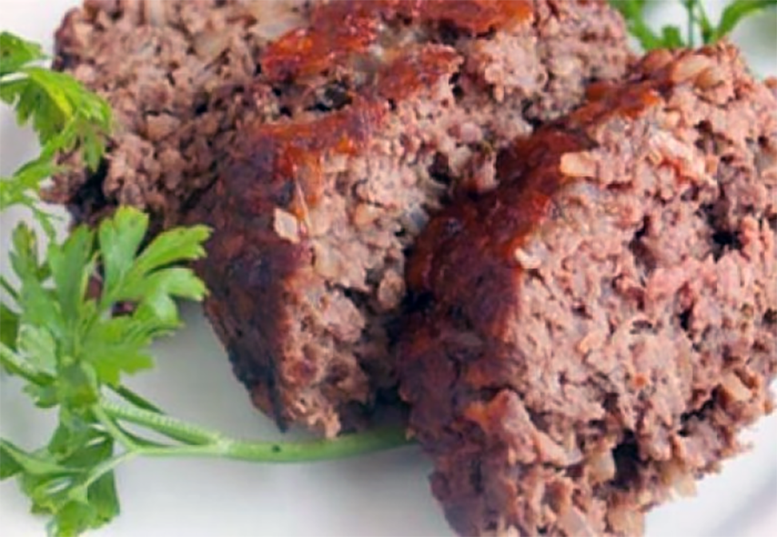 three slices of Brazilian meatloaf long on a plate with sprigs of parsley