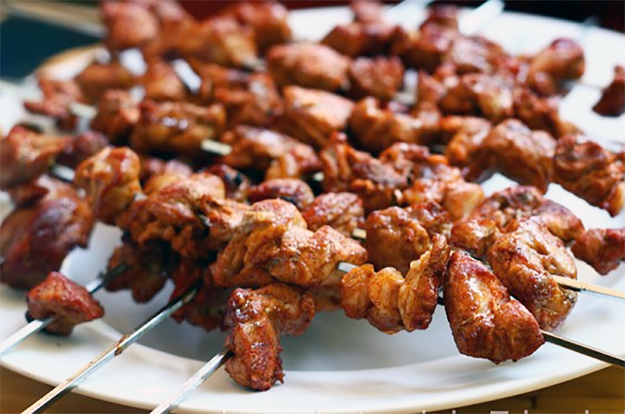 seasoned meat cooked on metal skewers