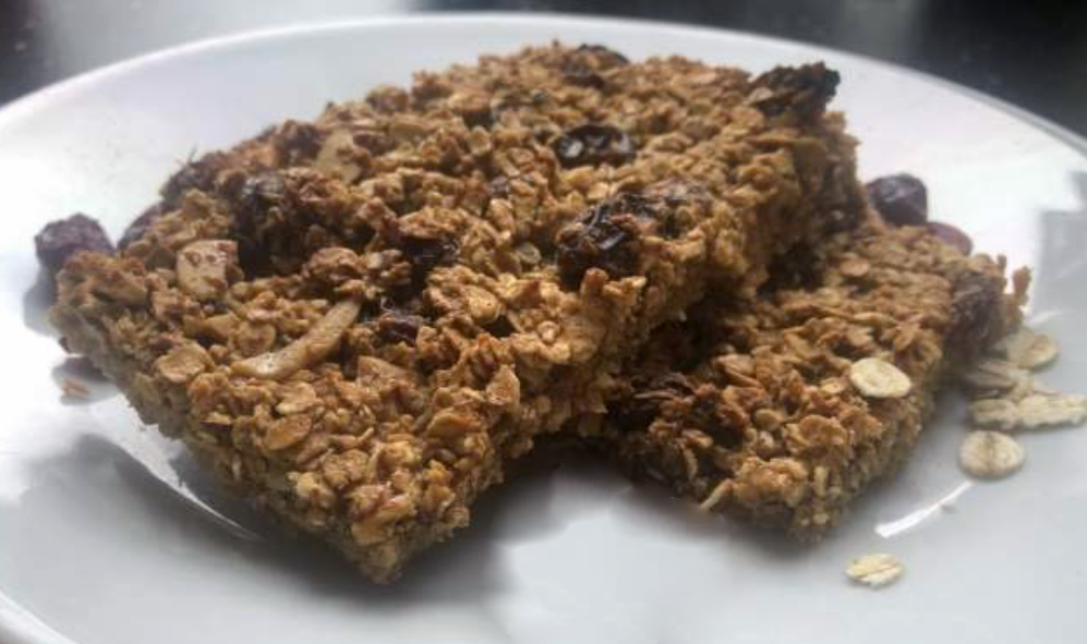 three butterless flapjacks with egg yolks, fruit and almonds on a white plate