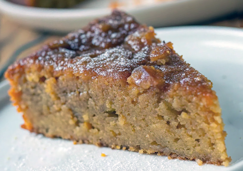 wedge of sweet potato cake on a plate dusted with icing sugar