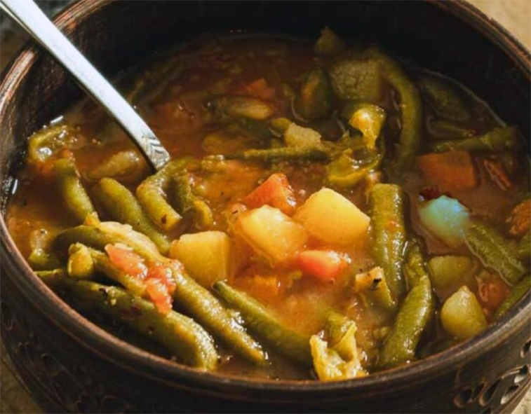 carrot, potato and green bean soup served in a bowl
