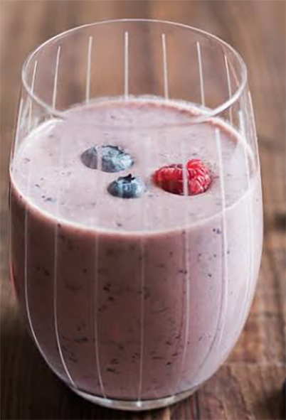 cherry cantaloupe smoothie garnished with two blueberries and a wild raspberry