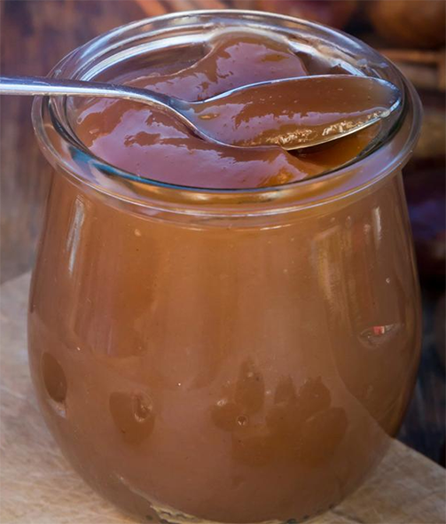 chestnut jam in a glass pot topped with a spoon