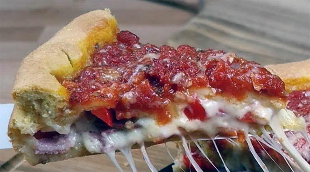 wedge of Chicago-style stuffed pizza lifted on a palette knife