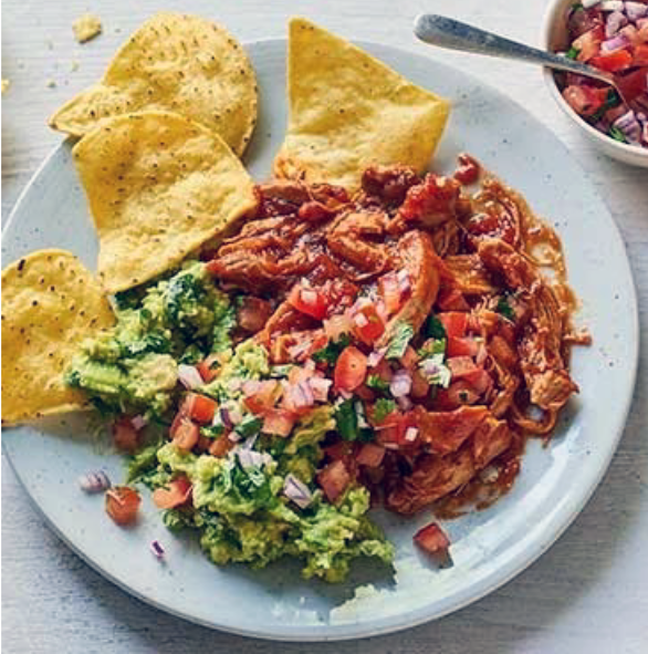 chipotle chicken tinga on a plate with guacamole and tortilla chips