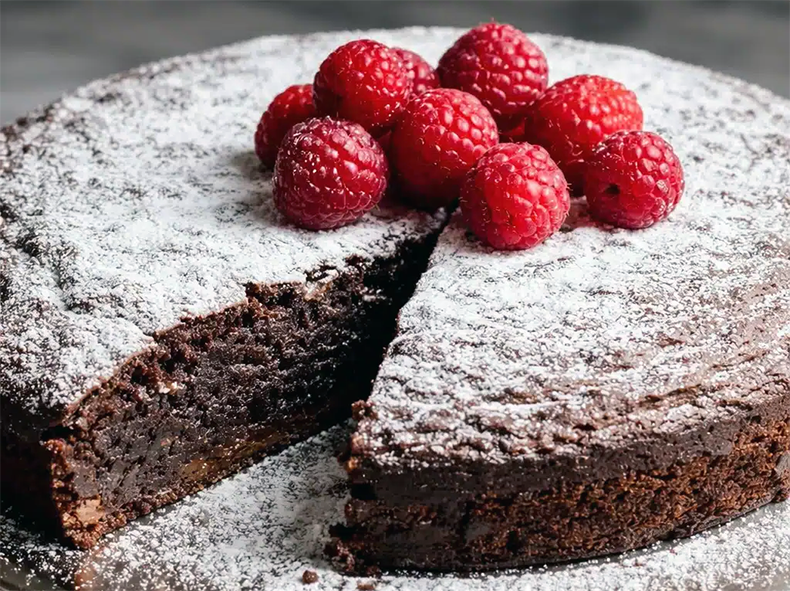 chocolate and haw flour cake garnished with powdered sugar and raspberries