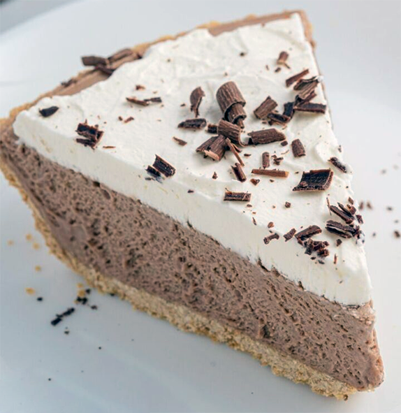 wedge of cream and chocolate shavings topped chocolate marshmallow pie on a plate