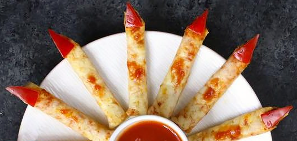 Hallowe'en pizza fingers served on a plate with a dip