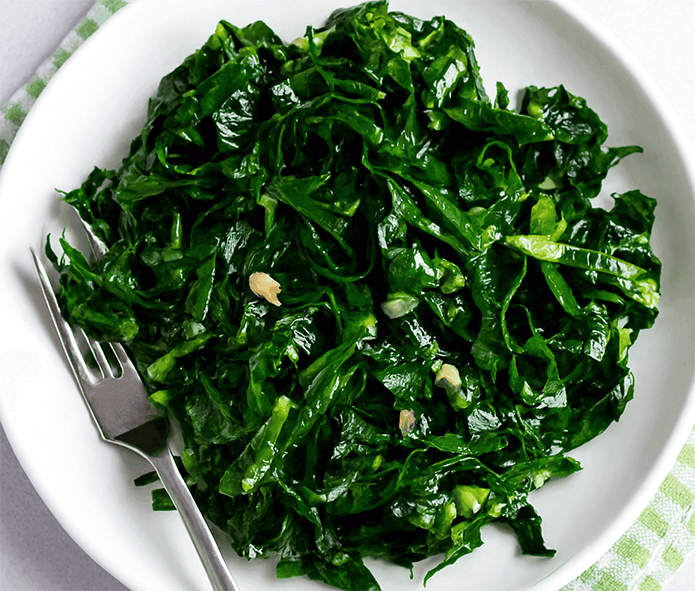 Portuguese fried collard greens served on a plate with a fork