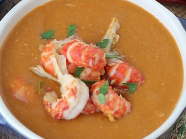 crayfish soup garnished with crayfish meats in a soup bowl