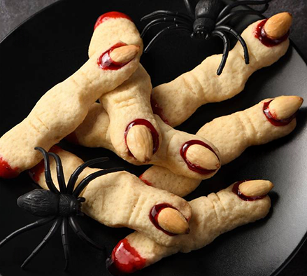 dough fingers with almond nails on a plate with plastic spiders