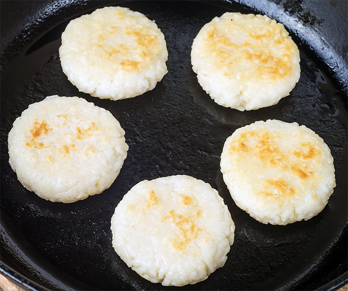rice cakes cooking in a cast iron skillet</a>