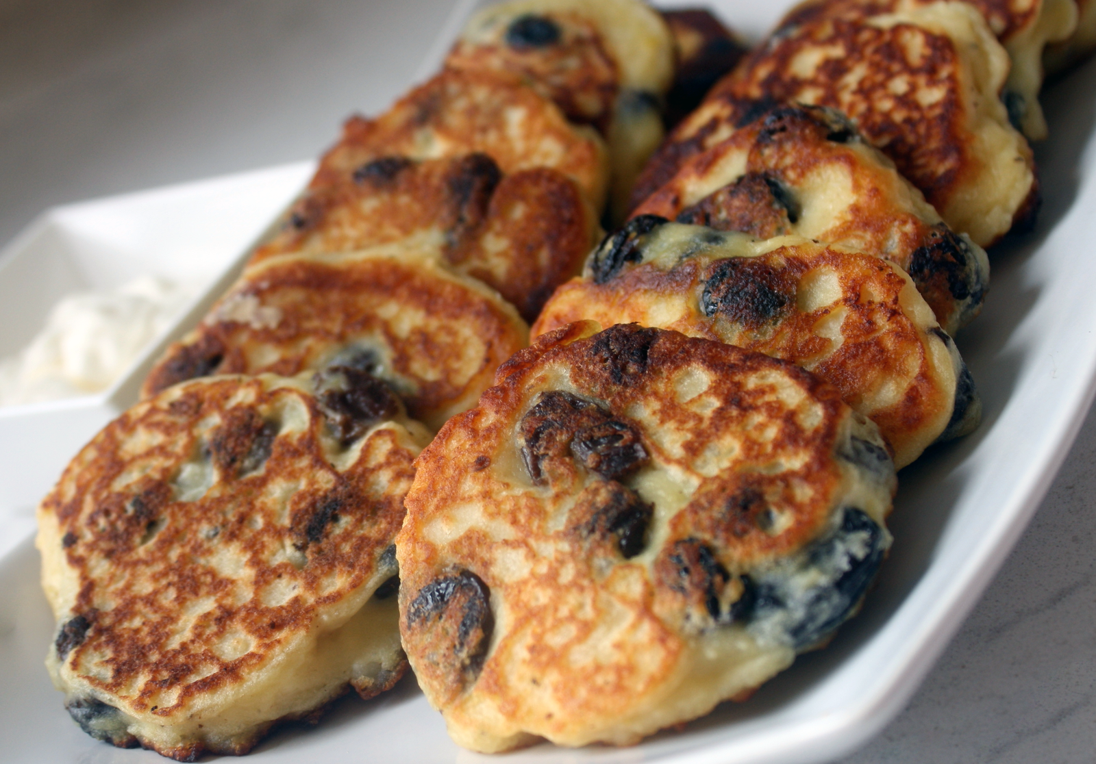 raisin pancakes baked in yorkshire pudding tins and stacked on a serving plate