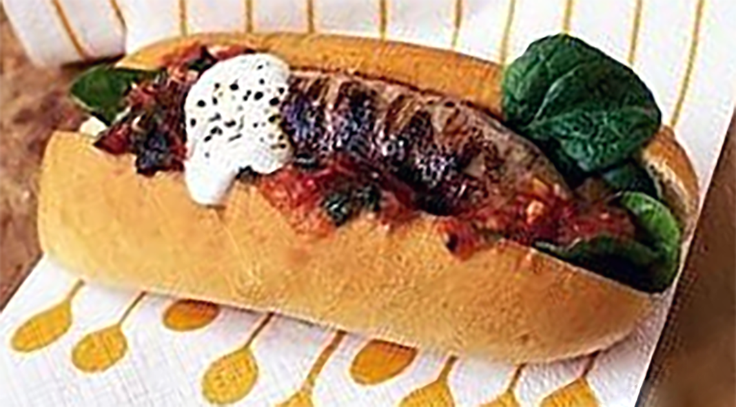 cumberland sausage hot dog with sweet chilli sauce and tomato relish served in waxed paper