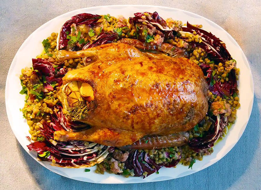 while roast duck stuffed with garlic served on a bed of radicchio, sausage meat and lentils