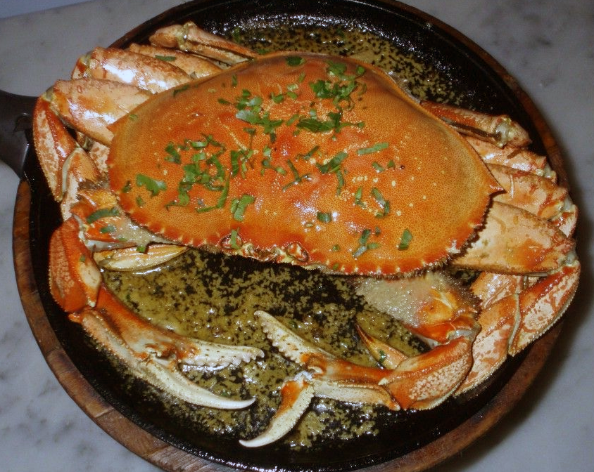 Dungeness crab roasted in a garlic sauce in a skillet