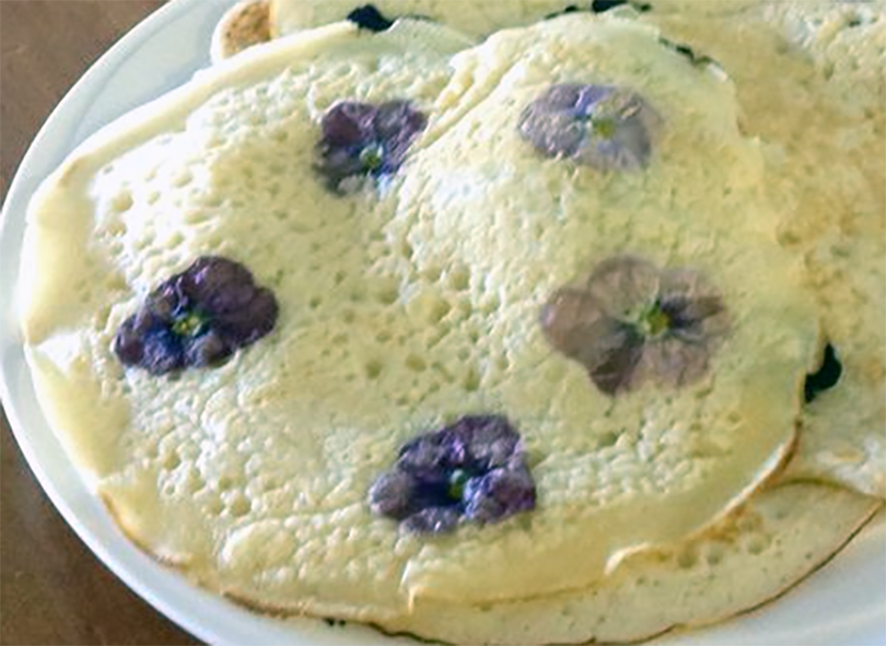 pancakes with edible pansy flowers cooked in the batter